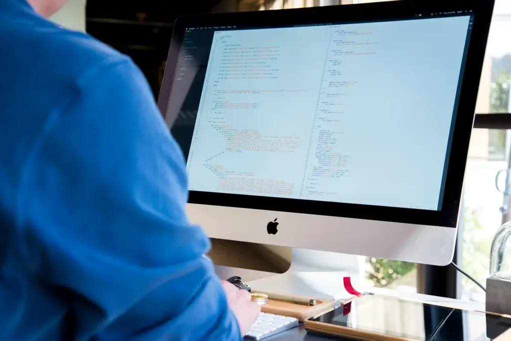 A developer looking at a laptop with a frustrated expression, symbolizing performance issues from re-renders