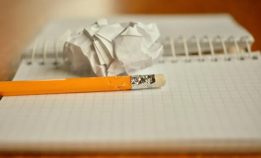Person sketching a grid layout in a notebook